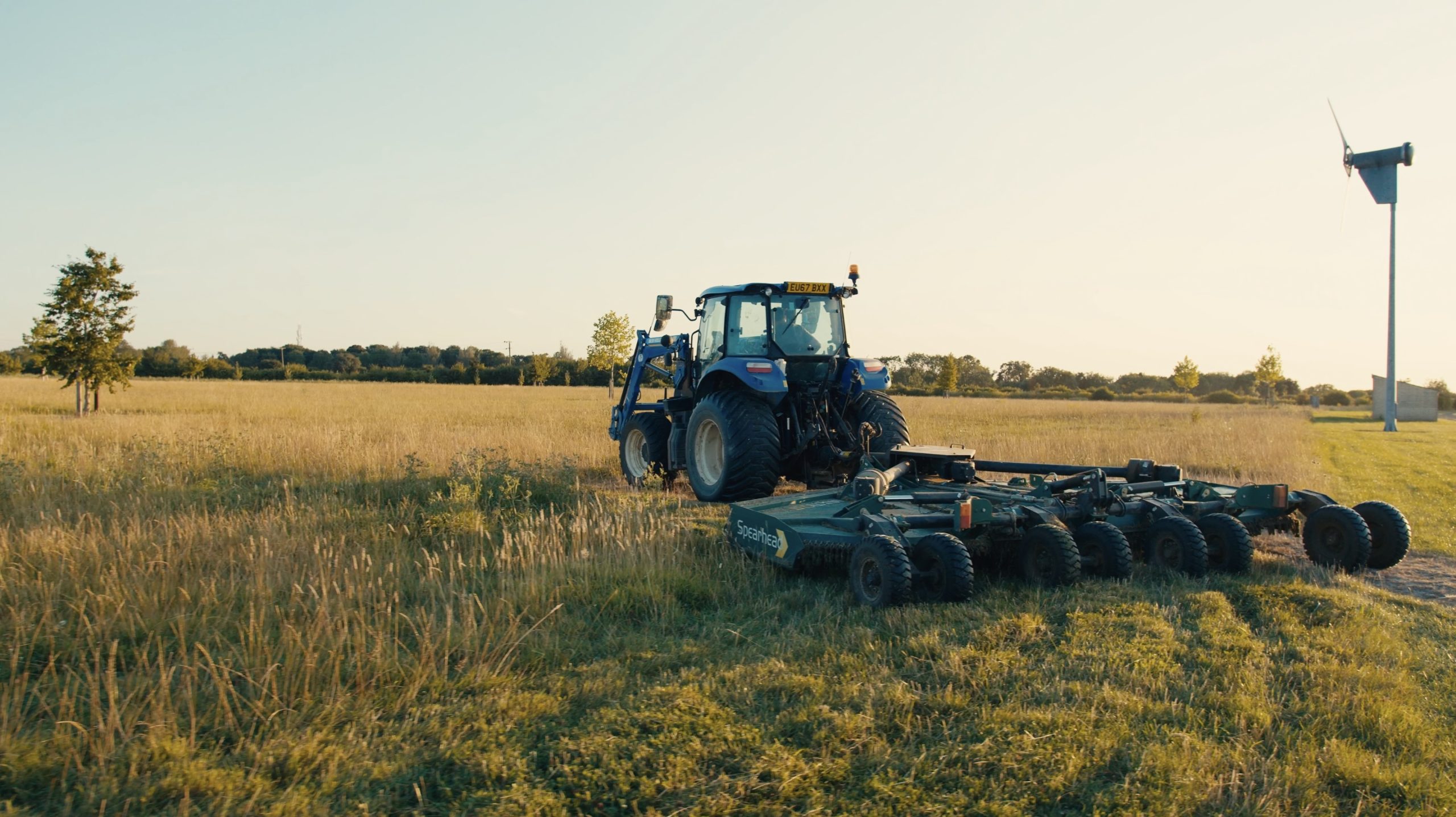 A tractor tending to a meadow, one example of BNG units at Hope Hall.
